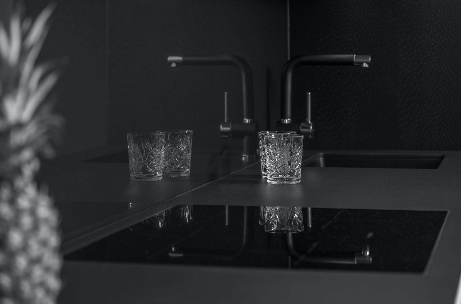 elegant and modern kitchen countertop with an ananas and two glasses black and white